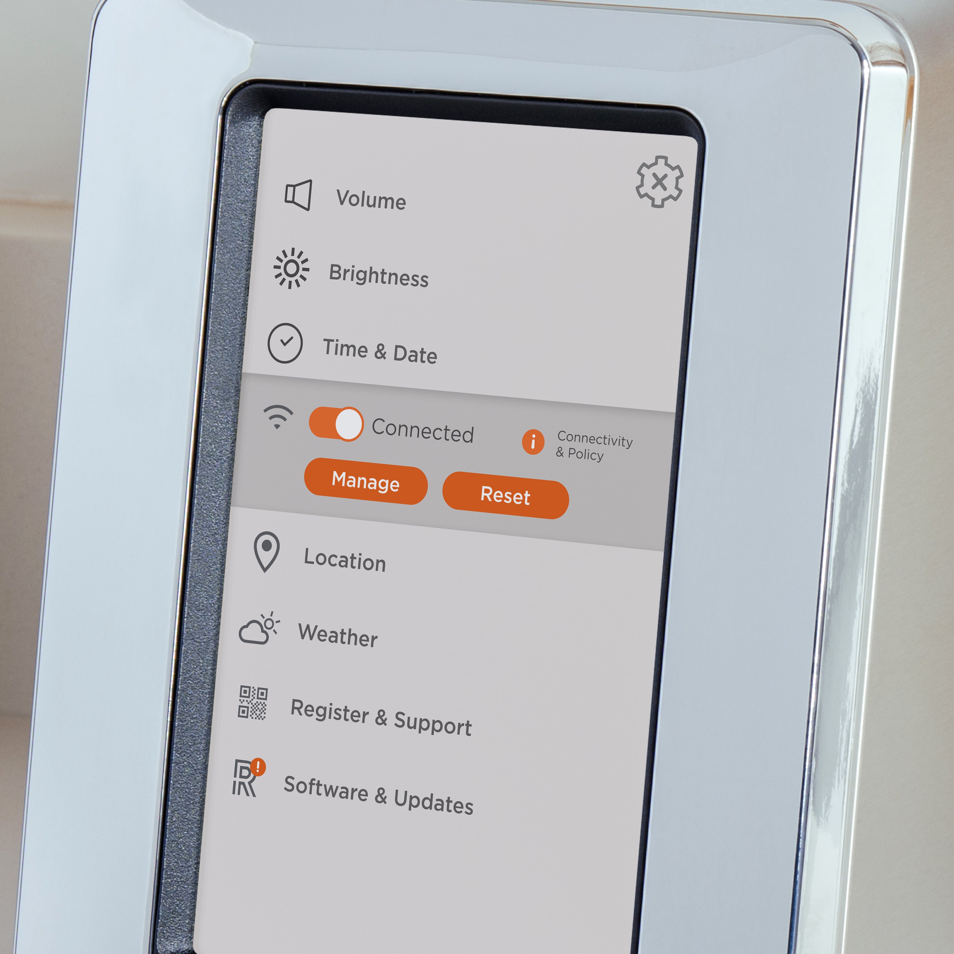 A close-up of a touchscreen interface displaying settings for volume, brightness, time & date, connectivity, location, weather, register & support, and software updates. The screen shows a connected Wi-Fi status with "Manage" and "Reset" buttons highlighted.